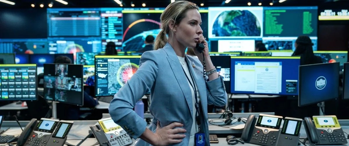 A production control room: an operator on the phone amid a wall of live on-screen graphics